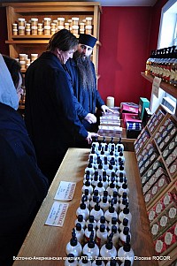 Fr.Alexander shows <br/>monastery merchandise to a visitor.
