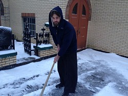 Br. Leo cleans snow in front of the monastery's<br/> main church