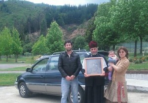 Fr Alexei and his family<br/>pose in front of the new car