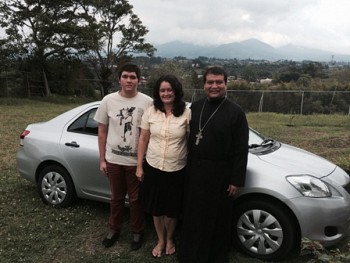 Fr Ignacio and his family pose in front of<br/>new parish car.